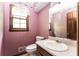 Bathroom featuring pink patterned wallpaper, a wood-framed mirror, and a single sink vanity at 3391 Quail Hollow Trl, Snellville, GA 30039