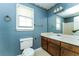 Bathroom featuring blue wallpaper, a large mirror, and a vanity with dark wood cabinets at 3391 Quail Hollow Trl, Snellville, GA 30039
