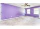 Bedroom with purple walls, carpet flooring, a ceiling fan, and natural light from two windows at 3391 Quail Hollow Trl, Snellville, GA 30039