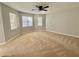 Spacious bedroom with neutral carpet, ceiling fan, and multiple windows for natural light at 5464 Fox Haven Trl, Stone Mountain, GA 30088