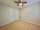 A bright secondary bedroom boasts neutral walls, a ceiling fan, and plush carpeting for a cozy retreat at 5464 Fox Haven Trl, Stone Mountain, GA 30088