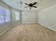 A bright primary bedroom boasts neutral walls, a ceiling fan, and plush carpeting for a cozy retreat at 5464 Fox Haven Trl, Stone Mountain, GA 30088