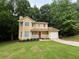 Charming two-story home with a welcoming front porch and attached garage in a wooded, green setting at 5464 Fox Haven Trl, Stone Mountain, GA 30088