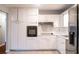 A well-lit kitchen boasts white cabinetry, a built-in oven, and ample countertop space for cooking at 679 Winchester Ln, Norcross, GA 30071