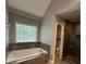 Bathroom with a large bathtub, walk-in shower, and natural light from a window at 1305 Lake Forest Ln, Mcdonough, GA 30253