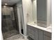 Elegant bathroom with double vanity, gray cabinetry, and a luxurious tiled shower at 1305 Lake Forest Ln, Mcdonough, GA 30253