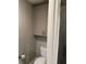 Bathroom featuring a toilet and cabinet near a modern glass shower with decorative tile at 1305 Lake Forest Ln, Mcdonough, GA 30253