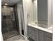 Bathroom with double vanity, cabinets, mirrors, and a tiled walk-in shower at 1305 Lake Forest Ln, Mcdonough, GA 30253