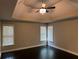 Serene bedroom featuring tray ceilings, large windows, and dark wood flooring at 1305 Lake Forest Ln, Mcdonough, GA 30253