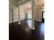 Dining room featuring dark wood floors, classic columns, and a chandelier illuminating the space at 1305 Lake Forest Ln, Mcdonough, GA 30253