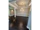Dining room with decorative chandelier, wainscoting, and dark wood flooring at 1305 Lake Forest Ln, Mcdonough, GA 30253