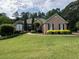 Beautiful brick home with lush landscaping and a well-manicured lawn at 1305 Lake Forest Ln, Mcdonough, GA 30253
