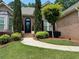 Charming brick home featuring manicured landscaping, mature trees, and inviting front entrance at 1305 Lake Forest Ln, Mcdonough, GA 30253