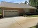 A two-car garage showcases the home's brick exterior and well-maintained landscaping at 1305 Lake Forest Ln, Mcdonough, GA 30253