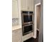 Gourmet kitchen features stainless steel double ovens and white custom cabinetry at 1305 Lake Forest Ln, Mcdonough, GA 30253