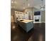 Modern kitchen island featuring a marble countertop, stainless steel appliances, and a fireplace in the background at 1305 Lake Forest Ln, Mcdonough, GA 30253