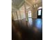 Elegant living room with dark wood floors, decorative columns, and a stylish chandelier at 1305 Lake Forest Ln, Mcdonough, GA 30253