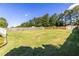 Expansive backyard featuring a lush lawn, wooden fence, shed, and tree line, perfect for outdoor activities at 1480 Shady Cove Ln, Lawrenceville, GA 30043