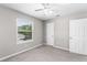 Carpeted bedroom featuring a window, ceiling fan, and a white door at 1480 Shady Cove Ln, Lawrenceville, GA 30043