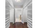 Walk-in closet with built-in shelving units and a view into the bathroom at 1480 Shady Cove Ln, Lawrenceville, GA 30043
