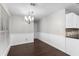 Dining area with wood floors, chandelier, and wainscoting adjacent to the kitchen at 1480 Shady Cove Ln, Lawrenceville, GA 30043