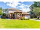 Beautiful home exterior with brick accents, lush green lawn, and mature trees at 1480 Shady Cove Ln, Lawrenceville, GA 30043