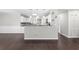Open concept kitchen with stainless steel appliances, granite counters, white cabinets, bar, and wood floors at 1480 Shady Cove Ln, Lawrenceville, GA 30043