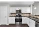 Well-lit kitchen featuring stainless steel appliances, granite countertops, and wood floors at 1480 Shady Cove Ln, Lawrenceville, GA 30043
