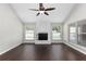 Bright living room featuring wood floors, a ceiling fan, white brick fireplace, and large windows at 1480 Shady Cove Ln, Lawrenceville, GA 30043
