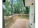 Back porch featuring stained wood floor and railing with view into a wooded lot at 1599 Sandtown Rd, Atlanta, GA 30311