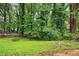 Lush backyard with mature trees and a glimpse of nearby houses, perfect for outdoor activities at 1599 Sandtown Rd, Atlanta, GA 30311