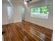 Bright bedroom with hardwood floors, white walls, and a large window overlooking the front yard at 1599 Sandtown Rd, Atlanta, GA 30311