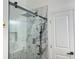 Modern shower featuring glass door, rainfall shower head, and elegant marble-style tile at 1599 Sandtown Rd, Atlanta, GA 30311