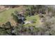 Aerial view of home with an expansive lawn, outbuildings, and wooded perimeter at 689 Hardin Rd, Temple, GA 30179