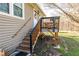 Side view of a charming home featuring a wooden staircase leading to a cozy elevated back porch at 689 Hardin Rd, Temple, GA 30179