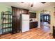 Traditional kitchen features dark wood cabinets, wood laminate flooring, and a refrigerator at 689 Hardin Rd, Temple, GA 30179