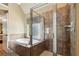 En-suite bath featuring a soaking tub and glass enclosed shower with tile surround at 1320 Magnolia Park Cir, Cumming, GA 30040