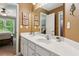 Bathroom with double sinks, white cabinets, and a large mirror at 1320 Magnolia Park Cir, Cumming, GA 30040