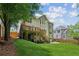 View of the back of a home with a well-maintained lawn, a wooden deck, and mature trees, offering a private outdoor space at 1320 Magnolia Park Cir, Cumming, GA 30040