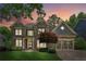 Stately brick home with a manicured lawn, showcasing its elegant facade and inviting curb appeal at sunset at 1320 Magnolia Park Cir, Cumming, GA 30040