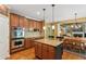 Open concept kitchen featuring an island, stainless oven, and warm wooden cabinetry at 1320 Magnolia Park Cir, Cumming, GA 30040