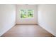 A sun-filled room with hardwood floors and two bright windows that let in lots of light and views of lush trees at 2561 Grapevine Cir # 104, Cumming, GA 30041