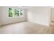 Sunlit bedroom featuring wood-look flooring, white walls, and three windows offering pleasant views at 2561 Grapevine Cir # 104, Cumming, GA 30041