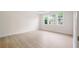 Bright bedroom with wood floors, white walls, and three windows providing ample natural light and neighborhood views at 2561 Grapevine Cir # 104, Cumming, GA 30041