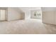 Spacious room featuring neutral carpet, white walls, and natural light from exterior windows at 2561 Grapevine Cir # 104, Cumming, GA 30041