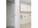 Laundry area has tile flooring and is equipped with white cabinetry above the hookups at 2561 Grapevine Cir # 104, Cumming, GA 30041