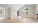 Bright living room with light hardwood floors, cathedral ceiling, and a large arched window offering ample natural light at 2561 Grapevine Cir # 104, Cumming, GA 30041