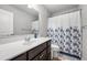 Bathroom featuring a single sink vanity with an oval mirror and a floral shower curtain at 4607 Underwood Walk, Powder Springs, GA 30127