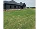 View of a large backyard from the home with a covered patio and fresh green grass at 1111 Lake Varner Dr, Covington, GA 30014