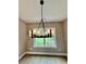 Modern chandelier illuminating a room with neutral walls, a window view, and hardwood floors at 1111 Lake Varner Dr, Covington, GA 30014